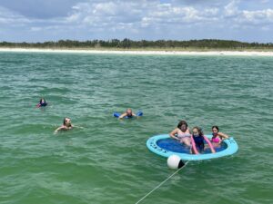 Family swimming off the coast of Naples, Florida during a Beach Club Charter with BRADventures yacht