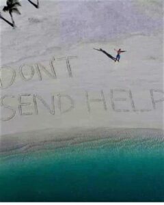 The Only Rescue We Need Is More Ice in the Cooler Drone shot of a person on a secluded beach next to large letters in the sand reading “DON’T SEND HELP” with turquoise water below.