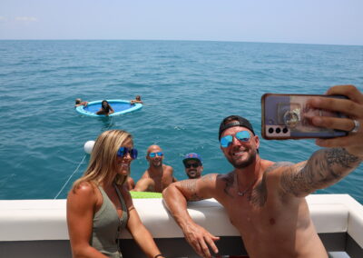 Guests floating and smiling during a LivBlue charter in Naples, Florida aboard BRADventures. Premium on-the-water experience with floats and full service.