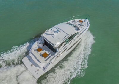 Aerial view of BRADventures yacht underway, showing sleek design, bow lounge, and aft sunpads