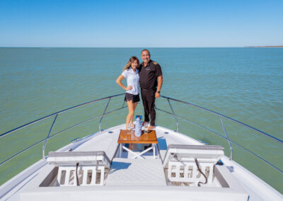 Captain Bill and Stew Samantha standing on the bow of BRADventures yacht with ocean backdrop