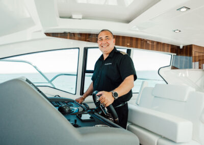 Captain Bill smiling at the helm of BRADventures yacht in Naples, FL