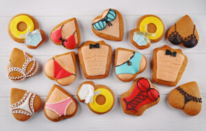Fun heart-shaped cookies decorated with lingerie and swimwear designs, perfect for lifestyle or bachelorette-themed events.